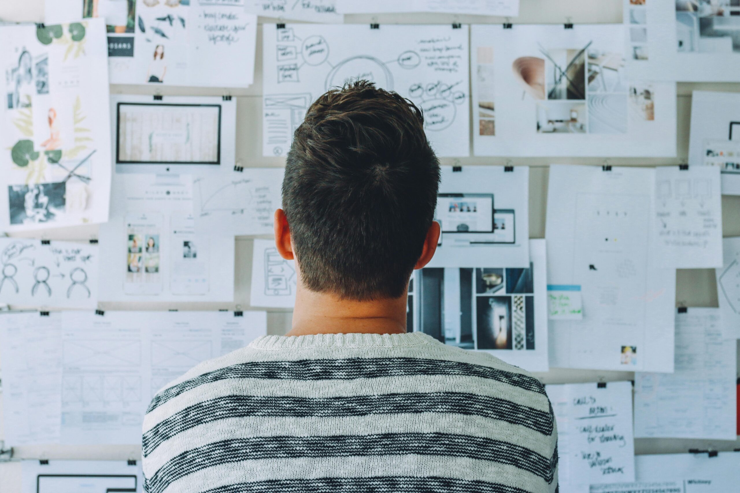 Man staring at strategic planning documents on a wall